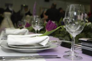 a table with a plate and wine glasses on it at Hotel Podravina in Koprivnica