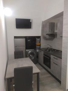 una cucina con un tavolo, una stufa e un lavandino di Help a Santeramo in Colle