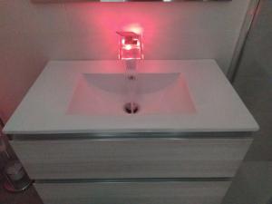 un lavandino in un bagno con una luce rosa di Help a Santeramo in Colle