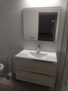 un bagno con lavandino e specchio di Help a Santeramo in Colle Altre 3 foto