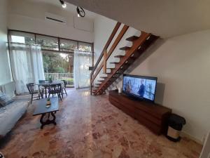 uma sala de estar com uma televisão e uma mesa de jantar em PORTICCIO BRILOC APPART DUPLEX à 150m de la plage. em Porticcio