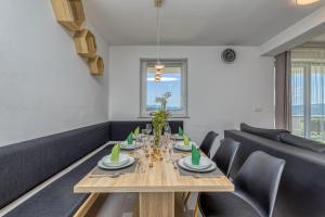 a dining room with a wooden table and chairs at Pool & Whirlpool Art Villas in Trebnje
