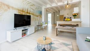 a living room with a television and a table at Strandurlaub Rügen "Lütt Oskar" in Binz