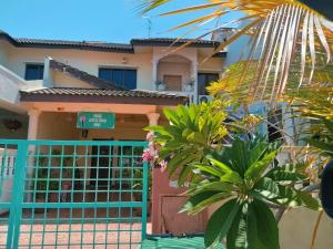 een huis met een blauwe poort en enkele planten bij 3 Little Birds Home, 100meter to JonkerWalk in Melaka
