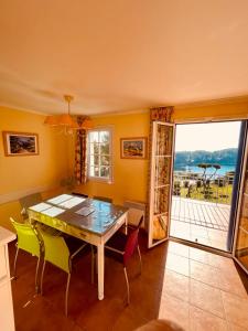 uma sala de jantar com uma mesa e cadeiras e uma janela em Appartement avec magnifique vue Piscine Lac et Mer Ref RDL 113 em Saint-Raphaël