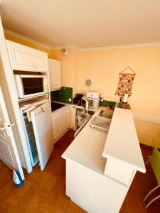 uma cozinha com um frigorífico branco e uma bancada branca em Appartement avec magnifique vue Piscine Lac et Mer Ref RDL 113 em Saint-Raphaël