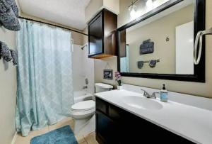 a bathroom with a sink and a toilet and a mirror at Modern Family Home, Close to Typhoon Texas and Tesla Gigafactory in Pflugerville +11 photos
