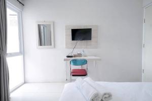 Habitación blanca con escritorio y ordenador. en Urbanview Hotel Bari Syariah Palembang By RedDoorz en Sukarami