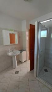 a bathroom with a white sink and a shower at Apartman Tija in Orebić