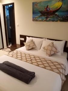 a bedroom with two beds and a painting on the wall at Golden Bird Heritage in Arpora