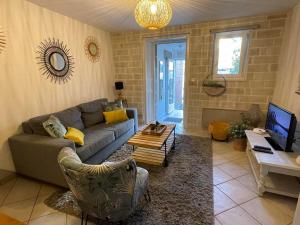 salon z kanapą i stołem w obiekcie Le Patio, coeur de ville avec garage et jardin w mieście Vannes