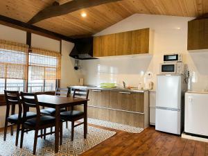 京都的住宿－Kurodani House，厨房配有桌椅和冰箱。