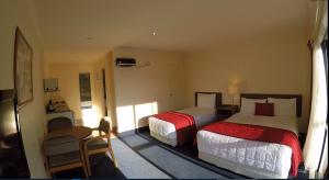a hotel room with two beds and a chair at The Peaks Motor Inn in Ohakune +23 photos