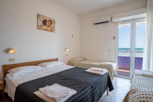 a bedroom with a bed and a view of the ocean at Beach Suite Hotel in Bellaria-Igea Marina