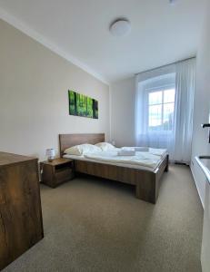ein Schlafzimmer mit einem großen Bett und einem Fenster in der Unterkunft Apartmány hotelu Ostrý in Železná Ruda