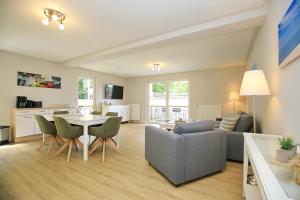 a living room with a couch and a table and chairs at Strandvilla Krabbe Wohnung 15 in Boltenhagen
