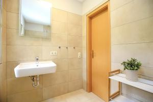 a bathroom with a sink and a mirror at Strandvilla Krabbe Wohnung 15 in Boltenhagen +20 photos