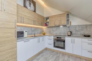 a kitchen with white cabinets and a clock on the wall at Pool & Whirlpool Art Villas in Trebnje