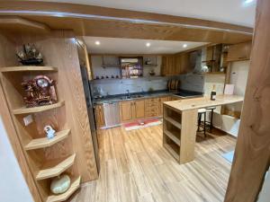 a kitchen with wooden cabinets and a table in it at Lakeview B & B Pogradec in Pogradec