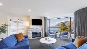 皇后镇Oaks Queenstown Shores Resort的带蓝色沙发和壁炉的客厅