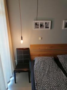 a bedroom with a bed and a chair and a lamp at Casa do Farol - апартамент с басейн до плажа in Chernomorets