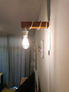une lampe suspendue à un mur près d'un réfrigérateur dans l'établissement Casa do Farol - апартамент с басейн до плажа, à Tchernomorets