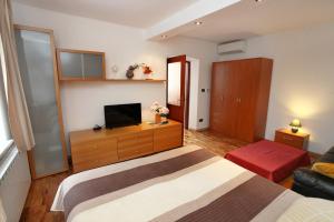 a hotel room with a bed and a television at Apartment Roxor in Portorož