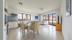 kuchnia i jadalnia ze stołem i krzesłami w obiekcie Apartamenty Sun & Snow Lido Sarbinowo w Sarbinowie