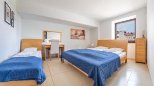 sypialnia z dwoma łóżkami, biurkiem i oknem w obiekcie Apartamenty Sun & Snow Lido Sarbinowo w Sarbinowie