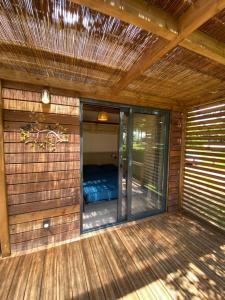 um alpendre com uma sauna com um telhado em Chalet panoramique avec vue sur étang em Bec-de-Mortagne