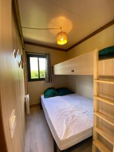 a bedroom with a bunk bed and a window at Chalet panoramique avec vue sur étang in Bec-de-Mortagne