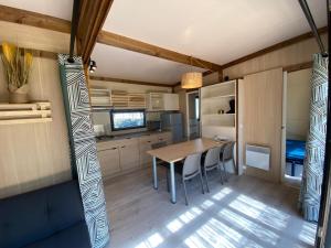 a kitchen with a table and chairs in a room at Chalet panoramique avec vue sur étang in Bec-de-Mortagne