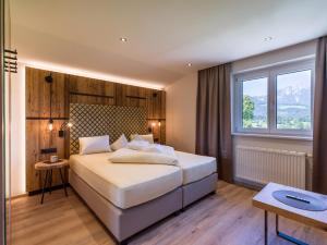a bedroom with a large bed and a window at Aparthotel Bergland in Söll