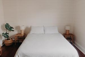 um quarto com uma cama branca e 2 candeeiros em The Allotment Albany - Centrally Located Cottage in Old Albany em Albany