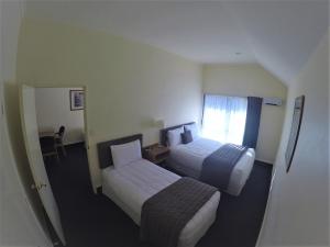 a hotel room with two beds and a window at The Peaks Motor Inn in Ohakune