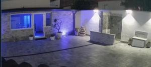 a patio lit up at night with a tv at LA CASA DELLE FATE-Area Marina Protetta in Isola delle Femmine