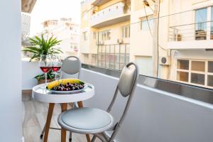 a table and chairs on a balcony with a bowl of fruit at ammos suites in Ierápetra