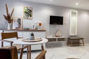 a living room with a table and a tv at ammos suites in Ierápetra