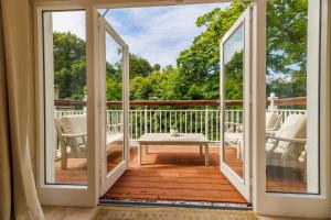 an open door to a deck with a table and chairs at Luxury 4 bedroom Lodge Mount Juliet Estate Thomastown Kilkenny in Oldtown
