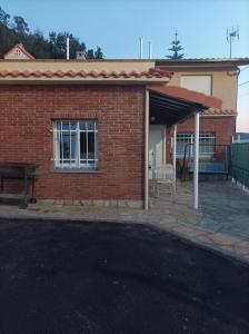 a brick house with a patio and a bench at Casa Cabárceno in Santiago