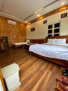 een slaapkamer met een groot bed en houten vloeren bij Sao Mai in Hội An