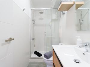 Un baño blanco con ducha y WC. en LuxuryFlats La Isleta - 2BR - Balcony - Parking - Beach, en Las Palmas de Gran Canaria 16 fotos más