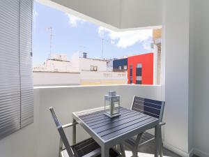 Una mesa y sillas en una habitación con ventana. en LuxuryFlats La Isleta - 2BR - Balcony - Parking - Beach, en Las Palmas de Gran Canaria