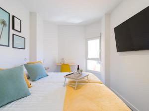 Una sala de estar con una cama y un televisor en una pared. en LuxuryFlats La Isleta - 2BR - Balcony - Parking - Beach, en Las Palmas de Gran Canaria