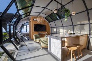 a room with a large glass ceiling with a table and chairs at Airship Bali by Alex Villas in Kuta