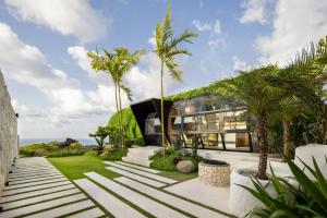 a house with palm trees in front of it at Airship Bali by Alex Villas in Kuta