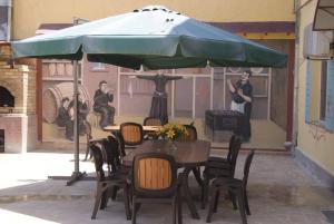a table and chairs with a blue umbrella at BONJOUR HOUSE in Yerevan