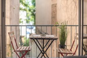 twee stoelen en een tafel op een balkon met een plant bij Elegant Mavili Suite by CloudKeys in Athene