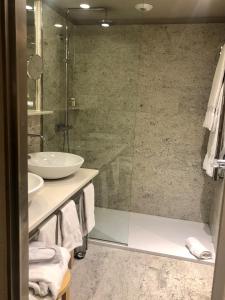 a bathroom with a glass shower and a sink at Gran Hotel Domine Bilbao in Bilbao
