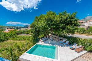 een uitzicht over een zwembad met stoelen en bomen bij Villa Gold Residence 2 in Mlini